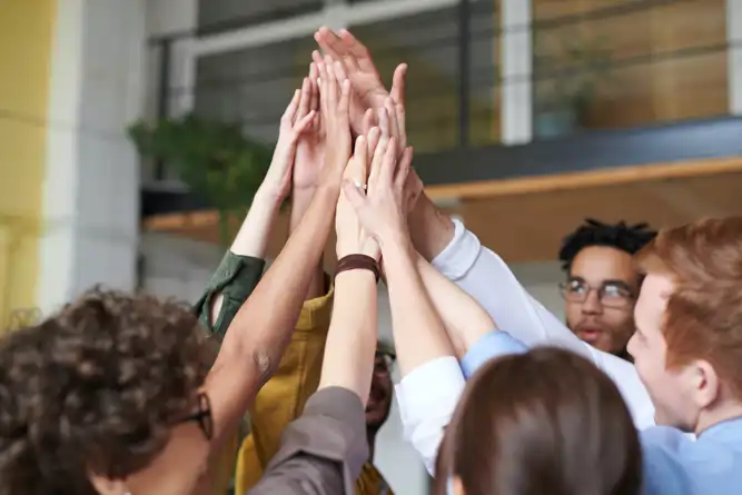 Auf dem Foto strecken verschiedene Leute ihren Arm in die Höhe und sich alle gemeinsam abzuklatschen. Wie wollen hiermit unsere Partner vorstellen.